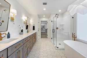 Owners bathroom with a freestanding tub, double vanity, double mirror, private bathroom, a European glass shower, recessed lighting, and a spacious closet