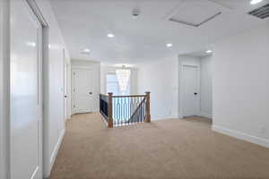 Loft with an upstairs landing, carpet, recessed lighting, a chandelier, and attic access