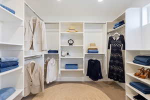 Walk in closet with light colored carpet