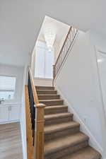 Stairway featuring a beautiful chandelier.