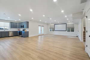 Living room featuring move screen wired for surround sound, second entrance, plenty of natural light, stairway, and french doors. ADU possibilty.
