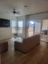 Living area with wood finished floors and ceiling fan