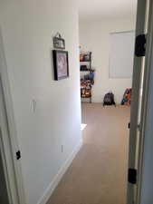 Corridor featuring carpet flooring