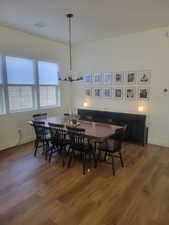 Dining space with a chandelier and dark wood-style floors