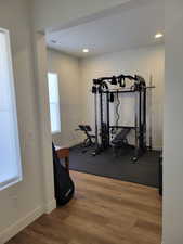 Workout area with light wood-style floors and recessed lighting