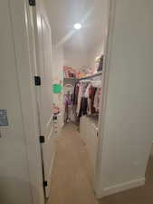 Spacious closet with light carpet