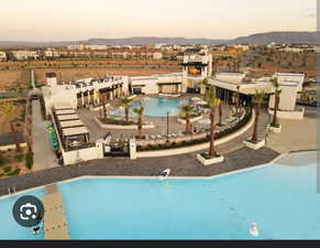 Pool at dusk with a community pool, a patio area, and a mountain view