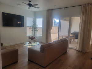 Living area with wood finished floors and a ceiling fan