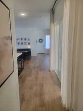 Hall with light wood-style flooring and baseboards