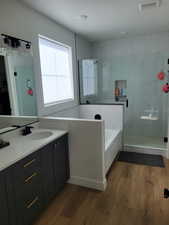 Full bath with vanity, dark wood-type flooring, a shower stall, and a bath