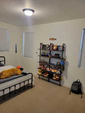 Bedroom featuring light carpet and a textured ceiling