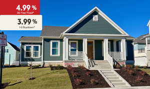View of front of home featuring covered porch, a front yard, and roof with shingles