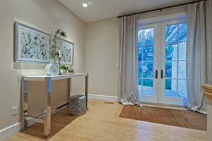 Office space with french doors, light wood finished floors, recessed lighting, and a baseboard radiator