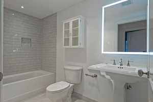 Full bath with light tile patterned floors and tub / shower combination