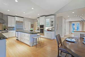 Kitchen with recessed lighting, white cabinetry, decorative backsplash, open shelves, and light wood-style floors