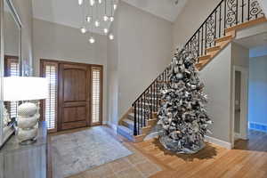 Entryway featuring stairway, a high ceiling, and wood finished floors