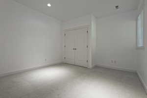 Unfurnished bedroom featuring light colored carpet, a closet, and recessed lighting