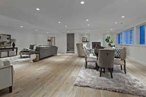 Dining space featuring recessed lighting, a fireplace, light wood-style floors, and stairway