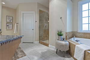 Full bathroom with a stall shower, vanity, light tile patterned floors, and a garden tub