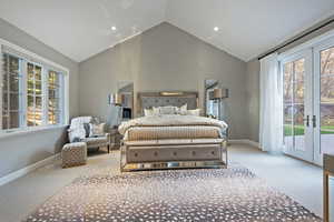 Carpeted bedroom featuring access to exterior, french doors, and high vaulted ceiling