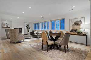 Dining space with recessed lighting, light wood finished floors, and a glass covered fireplace