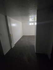 Below grade area featuring a textured ceiling and dark carpet