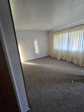 Carpeted empty room with a textured ceiling