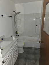 Full bathroom with bathtub / shower combination, vanity, and dark tile patterned floors