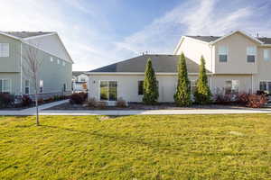 View of back facade featuring common greenspace and stucco siding