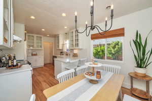 Dining space featuring recessed lighting, light wood-type flooring, and a chandelier