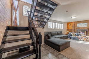 Stairway featuring a textured ceiling, tile patterned flooring, and wood walls