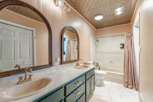 Full bathroom featuring shower / bath combo, double vanity, and light marble finish flooring