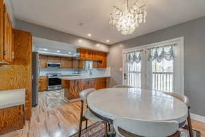 Dining area featuring light wood-style floors, recessed lighting, and a chandelier