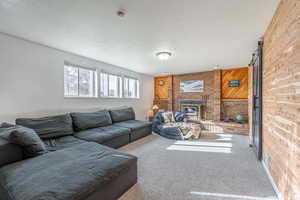 Living area with wood walls, carpet flooring, a textured ceiling, a barn door, and a wood stove