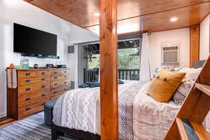 Bedroom featuring access to exterior, wood finished floors, recessed lighting, and a wall unit AC