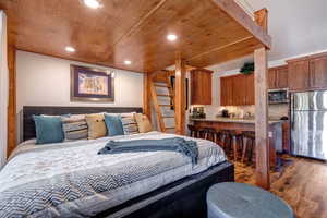 Bedroom featuring freestanding refrigerator, recessed lighting, wood finished floors, and wooden ceiling