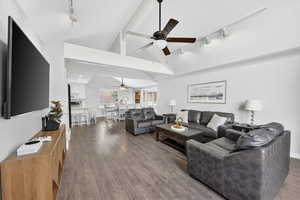 Living room with track lighting, a ceiling fan, and wood finished floors