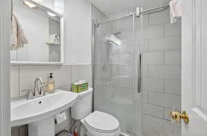 Bathroom featuring a stall shower and tile walls
