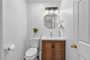 Half bathroom featuring vanity and toilet