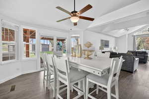 Dining space with vaulted ceiling, dark wood-type flooring, and a ceiling fan