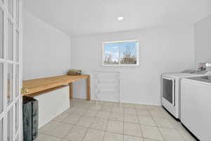 Laundry room featuring light tile patterned floors and washer and clothes dryer