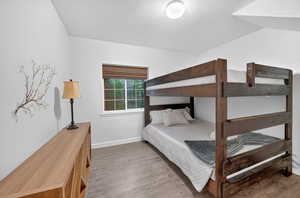 Bedroom with light wood finished floors and a textured ceiling