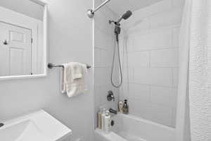 Full bathroom with shower / bath combination with curtain and vanity
