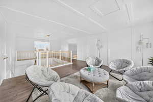 Living area featuring a decorative wall and wood finished floors