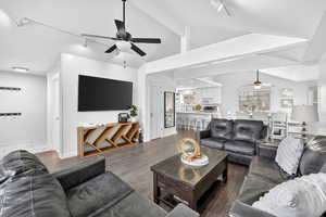 Living area with ceiling fan, rail lighting, and wood finished floors