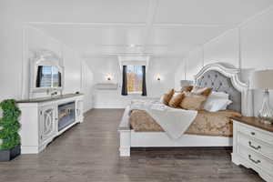 Bedroom featuring a decorative wall, wood finished floors, and coffered ceiling
