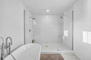 Full bathroom featuring a freestanding tub, a shower stall, tile patterned floors, and recessed lighting