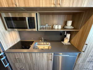 Bar area with appliances with stainless steel finishes, modern cabinets, and open shelves