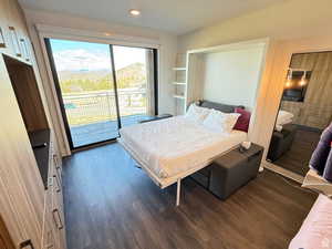 Bedroom featuring access to exterior, dark wood finished floors, and recessed lighting