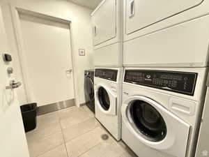 Laundry room featuring light tile patterned floors and stacked washer / drying machine